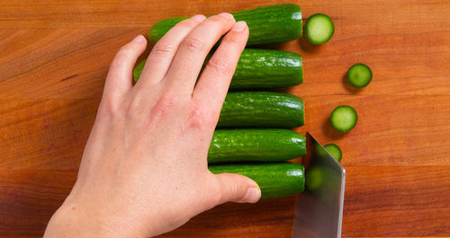 a pair of hands chopping zucchini
